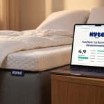 lit équipé d'un surmatelas de la marque Nyte et un ordinateur sur la table de nuit